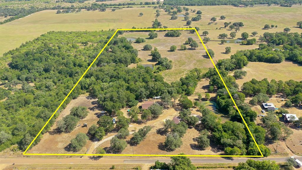 If quiet country living is what you are searching for, then search no further. This unique property has it all: multiple water sources, ponds stocked w/bass & catfish, beautiful post oak, live oak, elm, pecan trees throughout, a mix of open grassland & wooded areas, abundant wildlife inc. deer & turkey, & it has a great setup for farm/livestock. The 26.645 ac. inc. 4 ponds, Elm Creek, barn, hay barn w/tack room, 4 outbuildings, land fully & cross fenced, & animal enclosures. The cozy, country style 1,651 sqft. brick home has 3 bed, 2 bath, open concept living, dining, & kitchen, recently painted interior, split floorplan, primary bedroom w/ensuite & walk-in closet, wood burning fireplace, front & back porches, & screened in additional back porch. Replaced: septic '22, AC '18, roof on house & shop '18, & water heater '20/21. Additions: 16x40 building '18 & hay barn w/tack room '20. Minerals do not convey. See attached exclusions and disclosures. Lee Co. Water & Bluebonnet Electric.