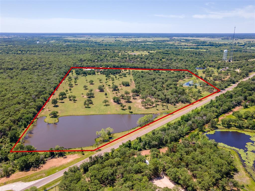Set up and Ready for an RV Business Opportunity, this 40.46 Acre Bastrop County Ranch is nestled off of FM 2104 in Smithville, Texas. 15 mins from Bastrop and 45 mins from Austin. 10 RV site stations, electric plug-ins, water, and lighting. One free standing cabin w/kitchen/bath/bdrm. Beautiful 3.75 acre lake. Walking trails and areas for dry camping. A 40x60 pre-engineered building with 3 roll-up doors, partitioned with one side being an entertainment center! Pool table, basketball game, and a 65” TV with surround sound. Recent A/C  and wood burning stove. Covered open air gazebo, fire pits and a skateboard mini ramp! Darling 1,248 sq ft one bdrm, open concept cottage, built-in computer desks, delightful kitchen, recent appliances, laundry room, sliding glass porch, and jacuzzi room. 22 KW Generac generator and 250 AG Propane tank. Deck on one side of the cottage, and 8ft fence on other. AG exempt. Ground equip is negotiable. List price: $3,495,000. Call listing agent for showing.