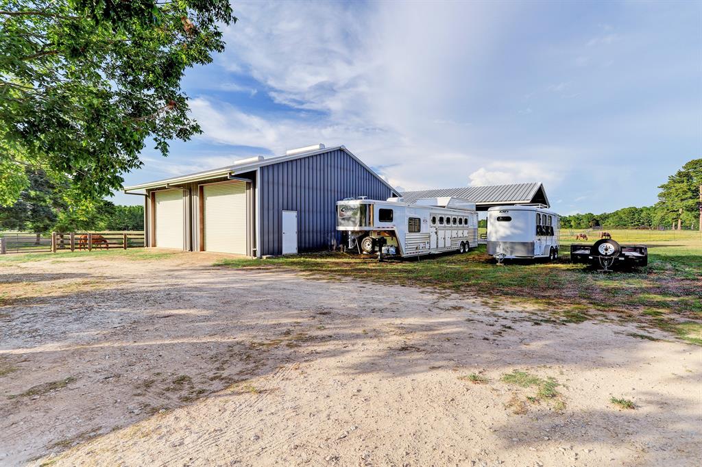 This auxiliary building is a shop with its private office, bathroom, 3 bays and hydraulic lift. The roof line behind the shop covers a grand lighted pavillion.