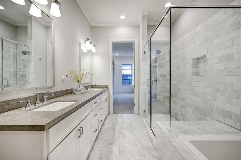 Primary bath with double sinks, soaking tub, and walk-in shower.