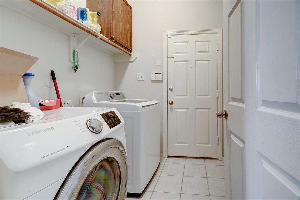 In the same hall as the secondary bedrooms is the utility room set up for side-by-side washer and dryer (electric connection).  The door leads to the two car garage.