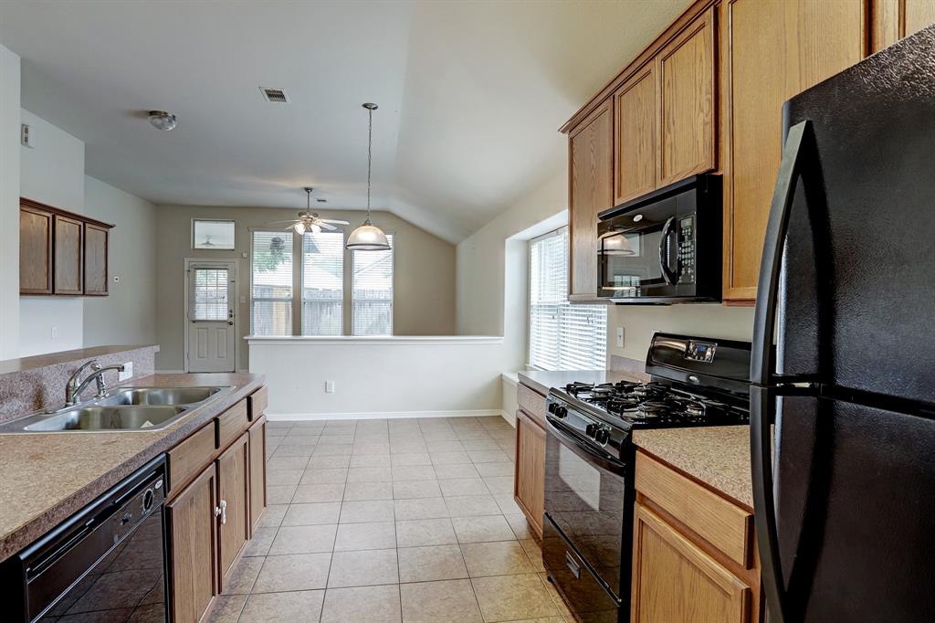 Immediately adjacent to the dining room is a kitchen with matching appliances and tile flooring.