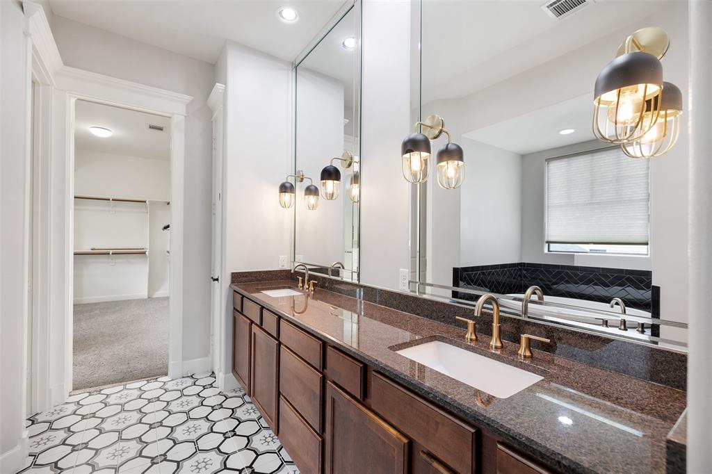 Custom tile work were added to this stunning primary bathroom suite. You will find plenty of storage and a large vanity with 2 sinks and custom light fixtures.