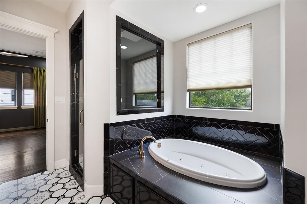 The primary bathroom also includes a large jetted tub and a separate shower with tile surround.