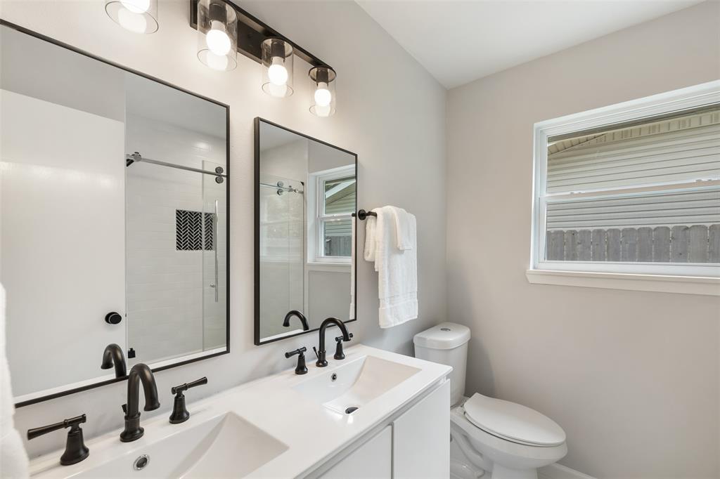 The updated hall bathroom features a vanity with double sinks and modern finishes.