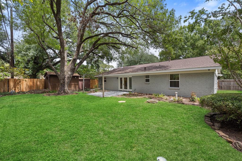 The spacious back yard features a patio and two storage sheds.