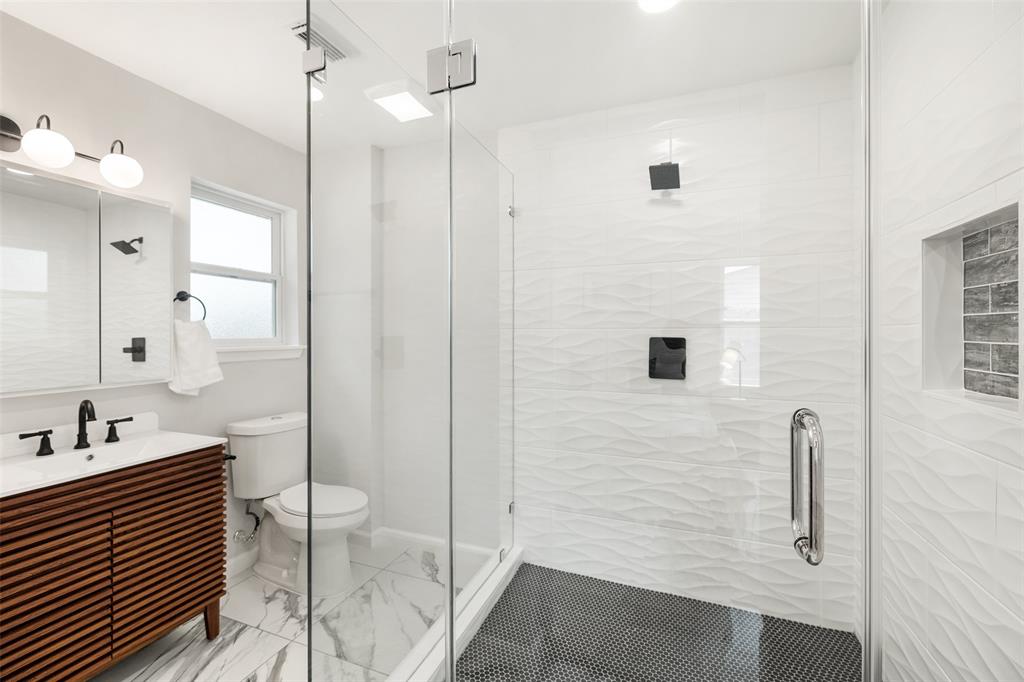 The primary bath features a huge walk-in shower with modern finishes and fixtures.