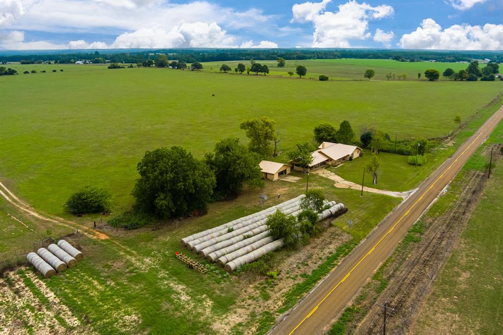 This 720.966-acre ranch is a turn-key set up for a cattle rancher looking to expand. Located just minutes from Grapeland, this beautiful property offers rich pastureland, 4-separate pastures fenced and cross fenced for rotational grazing, 3 spring fed ponds, working pens, great hay meadow, and approximately 2.5 miles of combined road frontage on FM 1272, CR 2290, and CR 2312. There is a brick, three bedroom, two and one-half bath ranch-style home, that would be perfect for your ranch foreman, or to be turned into your forever home. The home has an open living space with brick fireplace, spacious kitchen with plenty of cabinets and a breakfast nook, and a large laundry/mud rom with entry from the 2-car carport. The primary bedroom has a private bath, while two guest bedrooms share a hall bath. Outdoors, you will find a detached garage/shop, as well as a storage barn. This property has been owned by the same family for over 100-years, and this is the first time it’s been on the market.