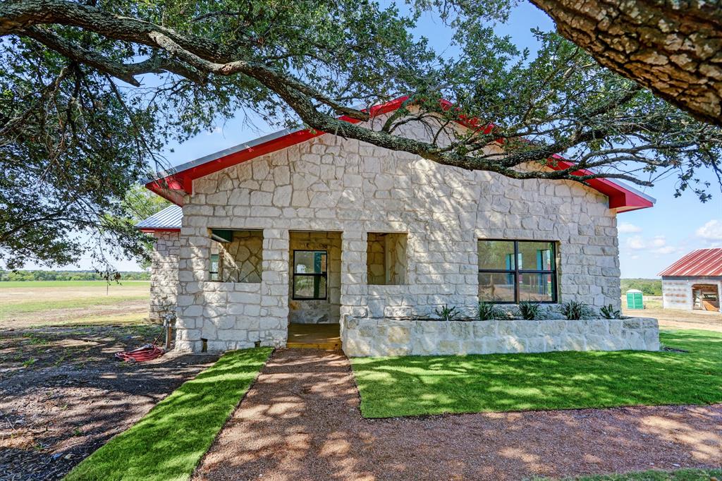 Charming rock home completely remodeled and ready for its next adventure. With its close proximity to Hwy 290 and Hwy 237 heading to Round Top, this property would make a great B&B! The main house has a great open floor plan with shiplap walls and ceilings and butcher block countertops with natural wood accents throughout. The bold tile in the bathrooms and kitchen backsplash will make this a home you won't forget. The main house has a fabulous deck for enjoying the 11+ acres. The fully functional guest house has one bedroom and one bathroom along with its own private deck. Host gatherings in the spacious red barn or use it to store your equipment. The possibilities are endless.