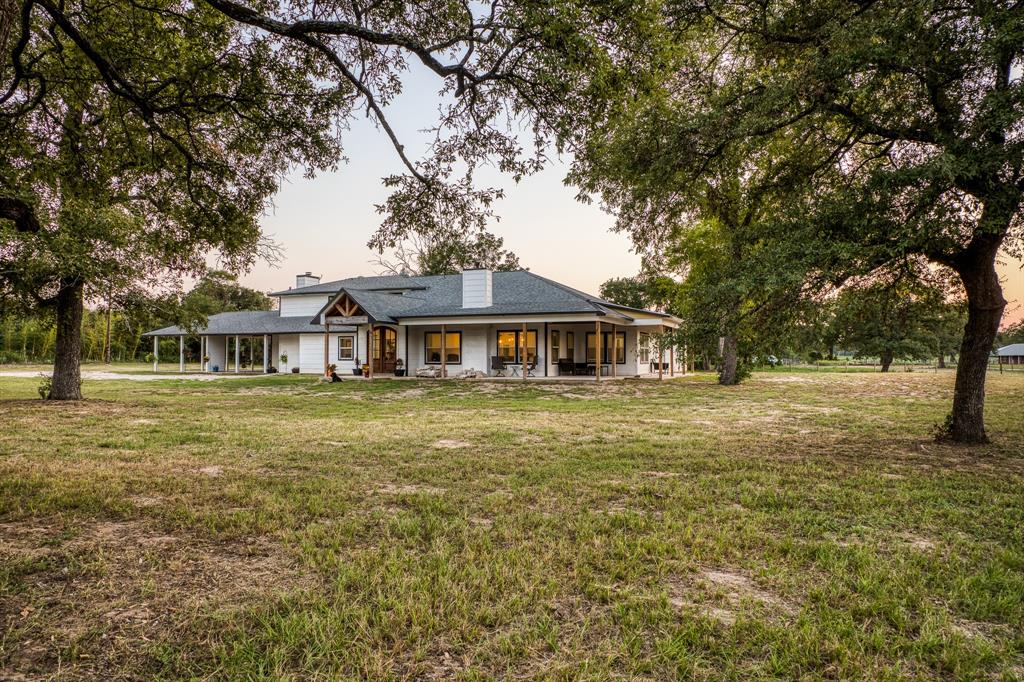 Are you looking for your forever home in a peaceful country setting just a short drive from Houston? This property incorporates the perfect mix of a rural setting with a classic farm house vibe from the original house, in addition to an updated modern & tastefully incorporated rendition of fine custom living w/over 4,000 sq ft. Multiple porches. 15 ag exempt acres. Custom kitchen provides an ambiance of warmth & charming character, extending a welcoming invite w/exposed wooden beam & custom light fixtures that compliment the natural wood tones seen throughout. Large granite island, double ovens, gas cooktop, pot filler, ornate wooden vent hood, oversized sink, walk-in pantry & wet bar. STORAGE! 2nd suite down. Relax in the primary suite with too many features to list. Office, formal sitting/dining combo & wood burning fireplace. 3 rooms and bath upstairs. 40’x60’ barn-water & electric available. 50-amp RV hookup. Recent electrical & pex plumbing. Finishing touches needed.