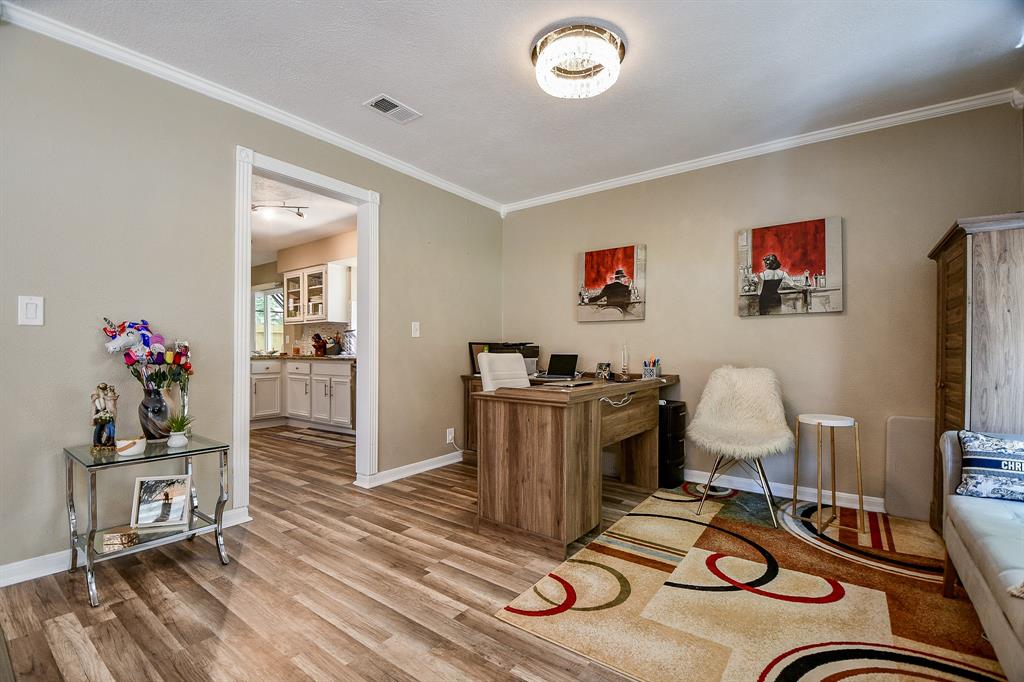 Earth tones fill this lovely space with classic crown molding and durable laminate, wood-look flooring.