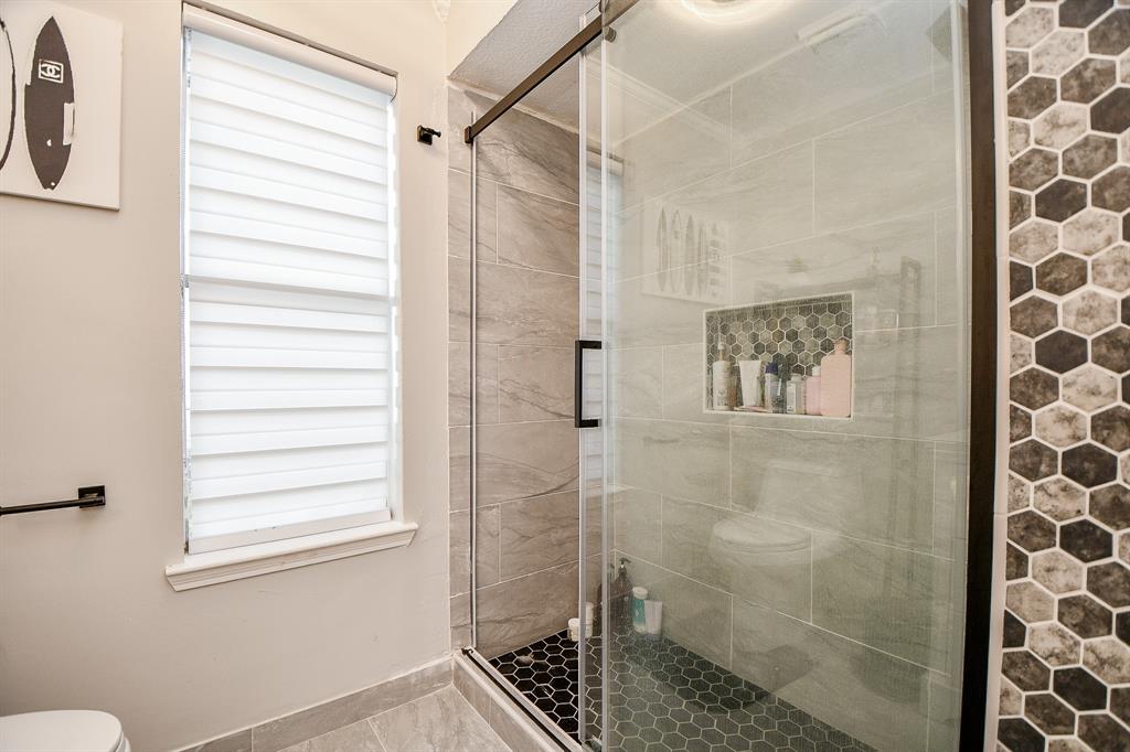 How spacious and beautiful is this glass enclosed secondary shower?