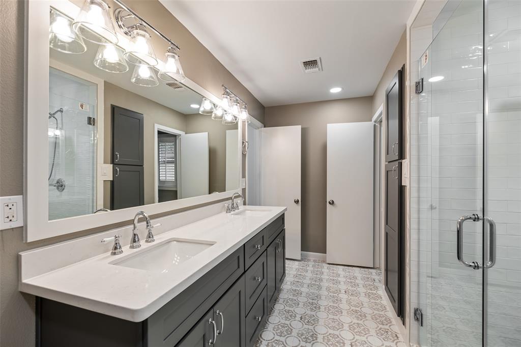 The primary bath features double sinks, large shower and modern tile and counter top selections.