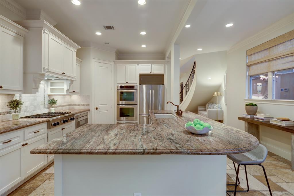 Open Kitchen with Slab Granite Counters, Tile Backsplash, Under-Cabinet Lighting and a Walk-In Pantry. Incredible Appliance Package, Including: KitchenAid 6 Burner Gas Cooktop with a custom Vent Hood, Double Ovens, Warming Drawer, Dishwasher, (Sharp) Microwave and Refrigerator/Freezer.