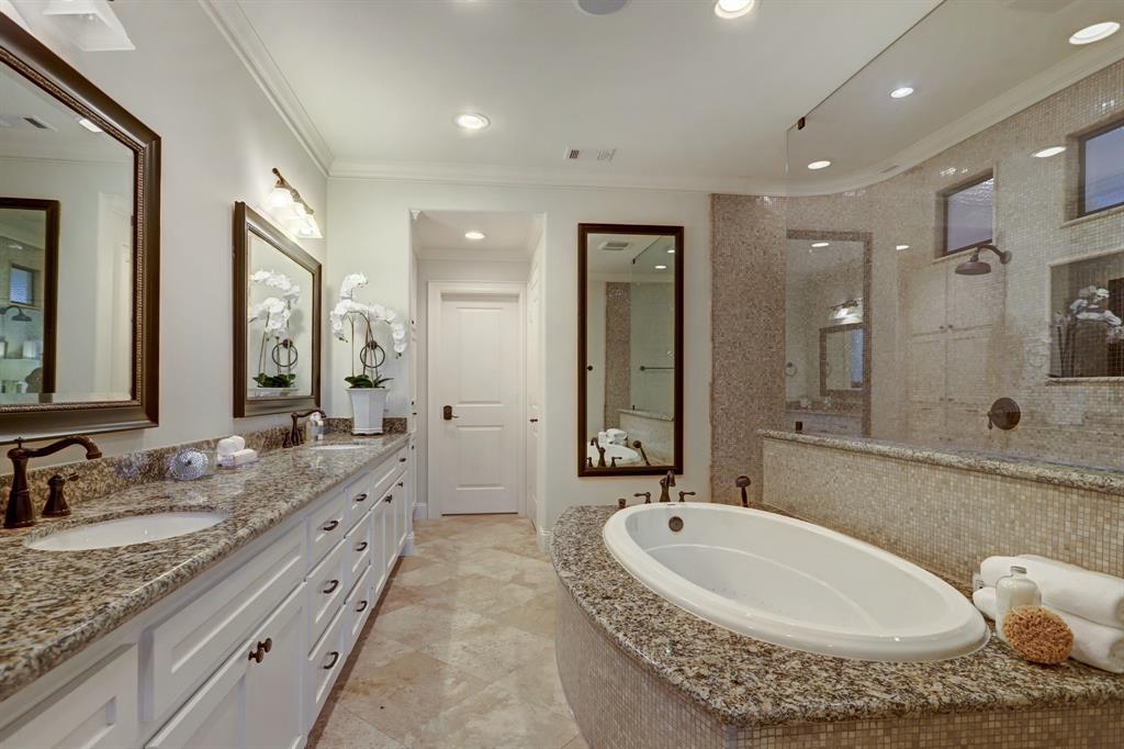 Travertine Tile Floor, Cabinetry, Slab Granite Counters, Dual Under-Mount Sinks, Framed Mirrors and Sconce Lighting. There is also a Separate Commode Area and Linen Storage.