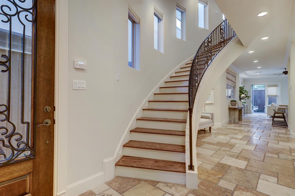 Entrance of home with a beautiful curved staircase, oaks treads on all stairs and gorgeous wrought iron railing. There is also accent lighting on the staircase for evenings.