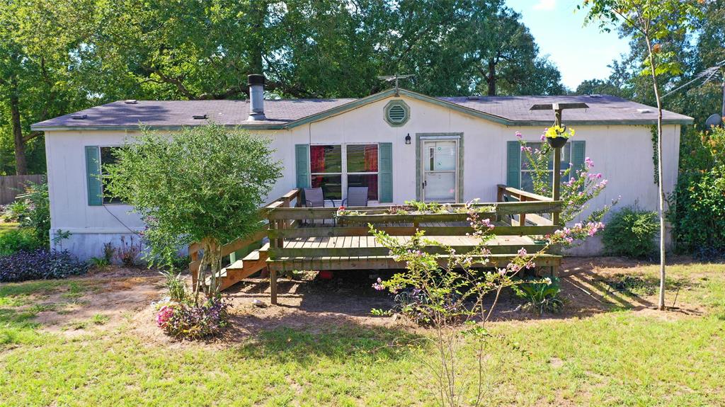 This double wide mobile home sits on 1.4986 acres.  Fully fenced yard with a gated driveway with a spacious front yard and another gate separates the backyard from the home and driveway.  Three fenced areas in the back could have multiple uses as a garden or for animal pens such as pigs, or chicken, or as previously, a dog rescue. Horses are allowed but not other large animals.  Scattered trees throughout creating lots of shady spots for the animals to rest.  Mobile home has a front deck and a back covered deck with a ramp. Inside there is a primary bedroom with a good size ensuite bathroom.  Two spacious secondary bedroom has their own walk in closets.  Kitchen has an island and a desk area and a dry bar perfect for your favorite drink.  This home needs some work but has lots of potential.  See virtually staged photos for some ideas!  No MUD tax as there is a community well and a septic tank.   Check out the virtual and video tours or schedule your appointment today!