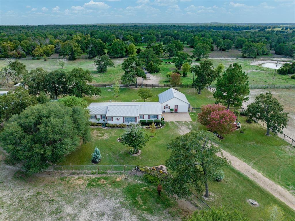 Ideally located down a private drive, this tranquil 8.691 acre property offers the opportunity to enjoy the true peace of the country.  The main house lives large with an open concept living/dining/kitchen with an island capped off by a fireplace, creating a welcoming space for friends and family to gather. The primary suite is complete with a copper soaking tub and  there is an additional bedroom and bath in the main house.  An expansive porch runs along the back of the house, providing panoramic views of the treed property and pond. The studio apartment has a full bathroom and impressive storage space.  The property is completely fenced and cross fenced.  The current owner runs a horse foaling operation and the business provides for an Ag Valuation on the property.