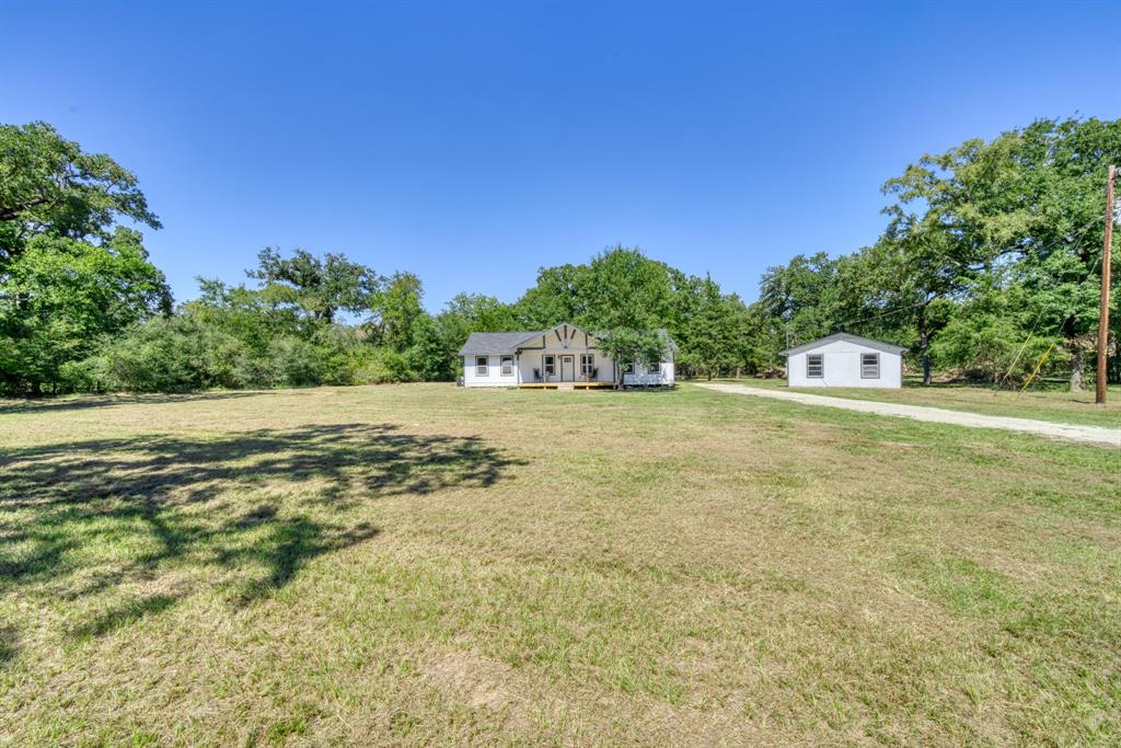 If You are Ready to move to the country, come and check out this Newly Refurbished Farmhouse in Grimes County. This 1670 SF home (CAD) is situated on 6.7+/- Wooded Acres with and additional 540 SF structure (per Seller) on a slab with plumbing and electricity already in place.  Finish this space out as extra living space, a craft room, mancave or shop.  The focal point of this charming home is the large, open front porch boasting high, exposed beams and picture frame windows.  New updates in this home include: Pex plumbing, shingle roof, gas water heater, HVAC, electrical upgrades, stainless-steel appliances, updated bathroom fixtures, 100% waterproof flooring throughout, kitchen stainless steel sink with detachable faucet, cabinets and butcher block countertops. 
Take this opportunity to live in the country to raise the animals you dreamed of or start a specialty garden. Located in the low tax area of Bedias 30 minutes from Huntsville and 45 minutes from Bryan/College Station.