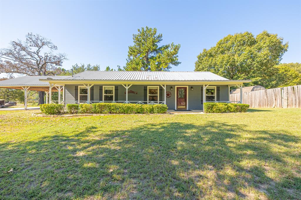 Charming and immaculate - this remodeled ranch style home with 2400 sq ft metal shop has everything you're looking for! It sits on nearly 4 acres on a semi-private lake just minutes from the conveniences of town & quick access to I-45. Completely remodeled in the last 5 years with a spacious eat-in kitchen with soft-close cabinets & drawers, granite countertops, tile backsplash, under counter lighting & stainless appliances. High ceilings & an open concept lend a very open & spacious feel to the kitchen & adjoining living room. The split floor plan offers a private primary suite with his & hers closets, sitting area or office space, & private bath. Two additional guest rooms share a stylish bath & are close to the large laundry room that rounds out the beautiful living space. Covered porches & concrete sidewalks lead to the metal shop with a finished office with full bath, cabinets, workbenches, sink. Quaint "she" shed & storage bldg are lakeside. So much to appreciate - come & see!