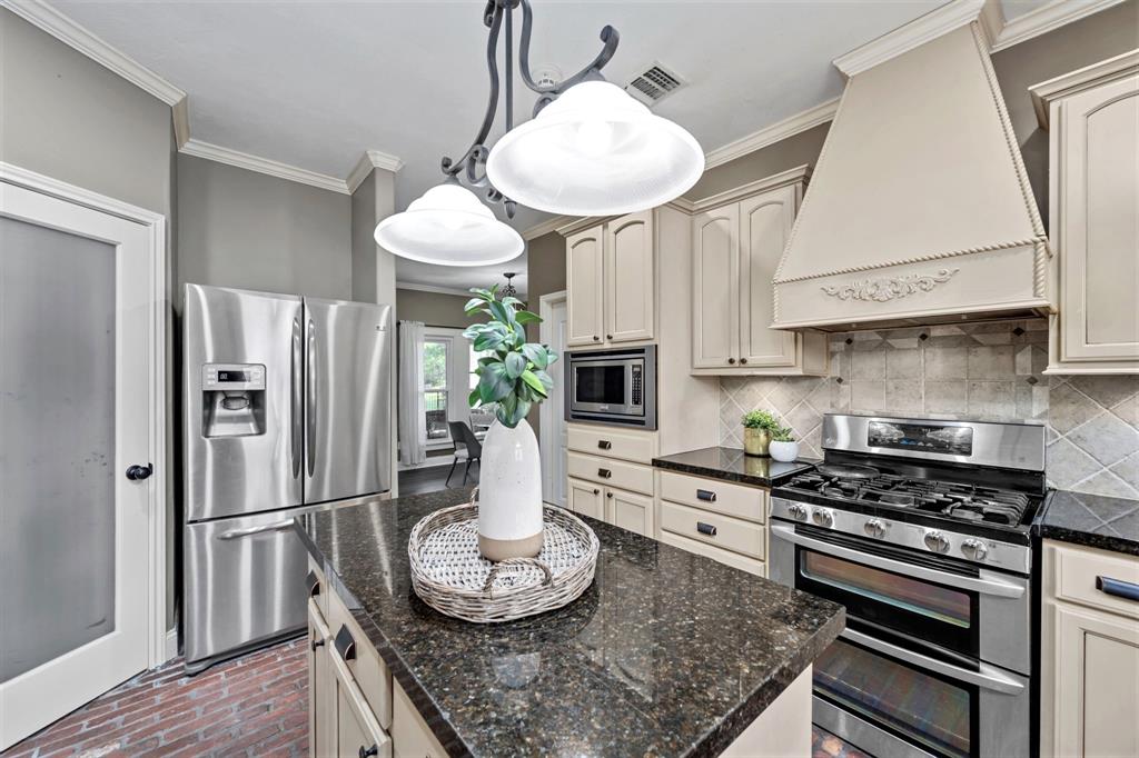 The Chef's kitchen has been beautifully-updated to include elegant granite counters and modern stainless steel appliances; including double ovens, a 5-burner range with a vent hood, and a built-in microwave. The fridge also stays!