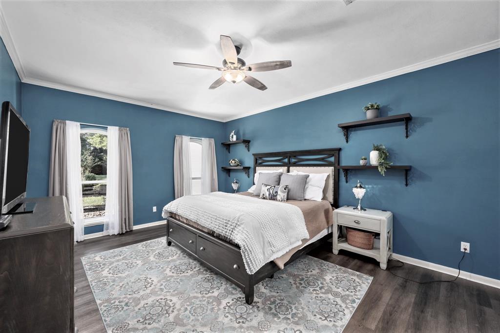Escape to the first-floor Primary Suite, where vinyl plank floors continue. A warm-toned color palette creates the ultimate ambiance for a relaxing night's sleep.