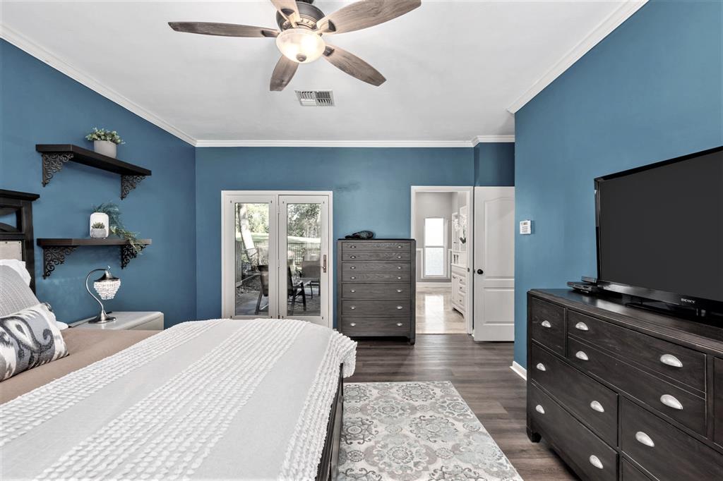 An alternate view of the Primary Suite looking toward your private covered patio and en-suite bathroom. There's plenty of space for a King bed with room to spare.