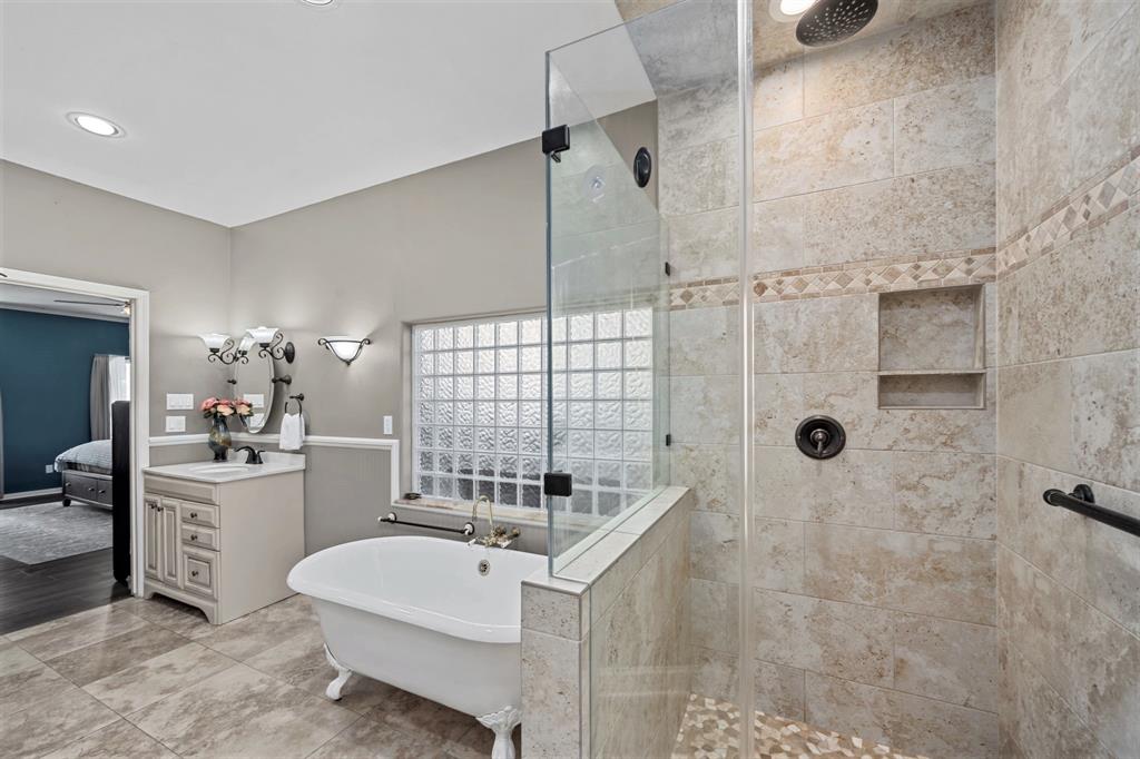 Enjoy the option of a relaxing garden tub and separate glass-enclosed shower with decorative tile. The glass brick window allows for natural light without sacrificing privacy.