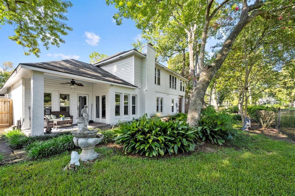 An alternate view of the backyard shows green space for your four-legged family members. Also take note of the classy white exterior with many windows to flood the home with natural light.