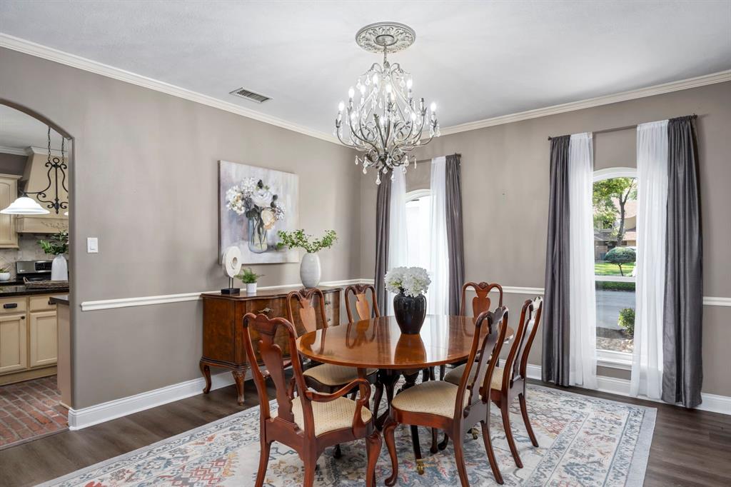 Find this elegant formal dining room located near the foyer, featuring chair rails, and a stunning chandelier under which to place your dining table.