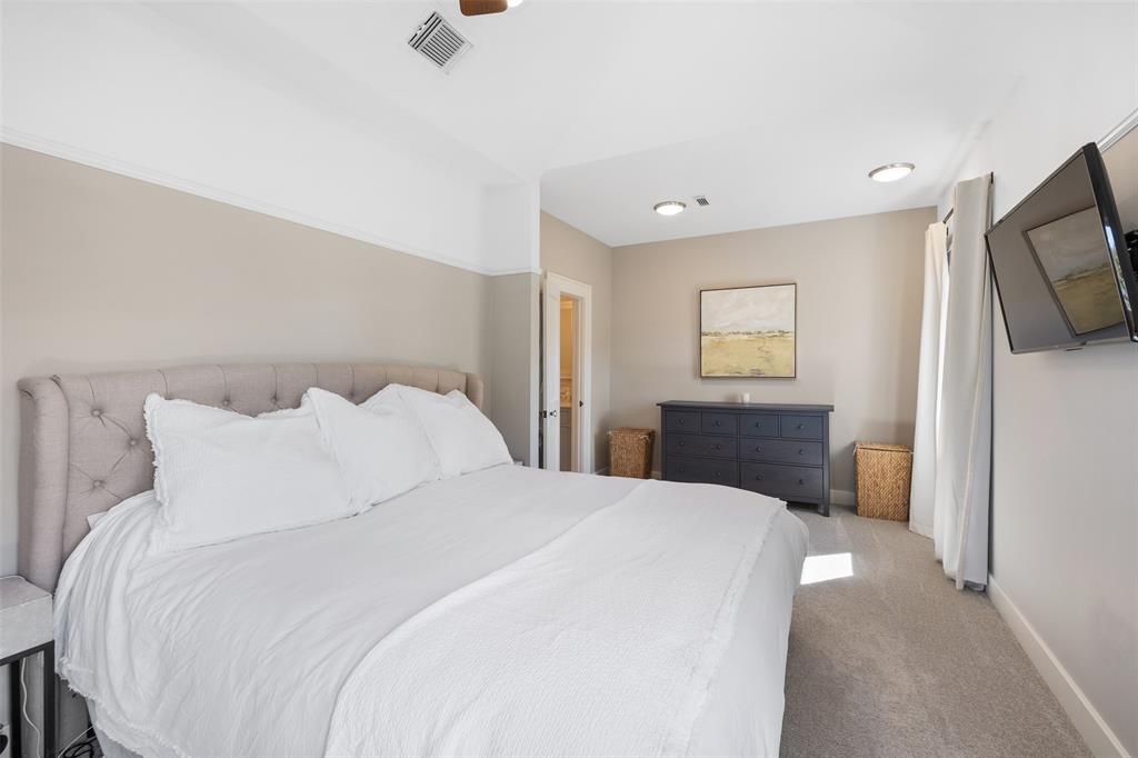 The primary suite features a vaulted ceiling, recessed lights and a walk-in closet.