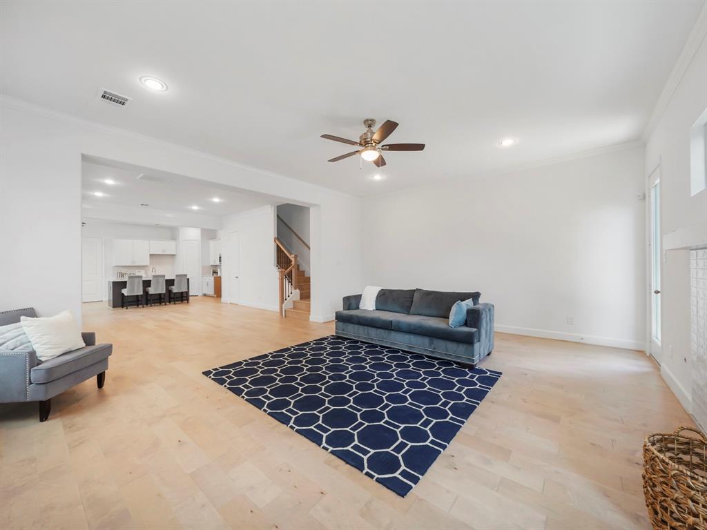 A large space for entertainment and relaxation, this Living Area boasts wood flooring and large windows, with an abundance of natural light. The space opens to the kitchen and dining area, creating the perfect open-concept layout