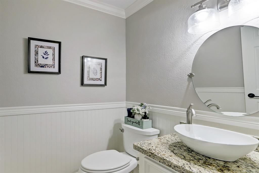 The (always necessary) downstairs half-bathroom helps showcase the elegant nature of this property. Wainscotting, granite, vessel sink, finishes, crown molding etc.