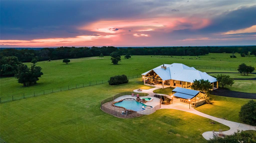 Get ready to be left speechless! Located just a short drive from Kyle Field & Texas A&M sits this beautiful +/- 113 acre ranch in Bryan, TX. The terrain includes a mixture of open pasture land and wooded areas making it great for recreational or agricultural use. Water features include 2 small ponds and a +/- 1 acre stocked pond with bass, crappie, & catfish that has an aluminum dock for fishing. Fencing included on the property is 8 ft galvanized high fence with a 4 ft varmint wire and hot wire. The property includes a 3,312 sq ft 5 bed, 4.5 bath main house, a 4,800 sq ft bardominium with full kitchen, wet bar, eating bar, 2 bed & 2.5 bath, and a 1,462 sq ft 2 bed, 1 bath house at the front of the property. Also included on the property is 15 small sheds for animals in breeding pens, 40x40 hay barn, 40x40 deer barn, and a 30x50 equipment barn. The main house features an open concept floor plan with stone accents, wood floors, fireplace, beams, wet bar and more.