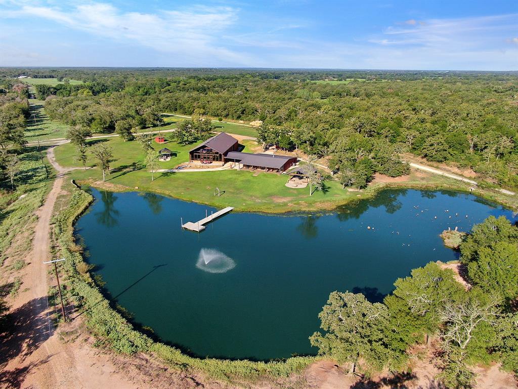 BIG CREEK RANCH is just minutes to TEXAS A&M and LAKE SOMERVILLE - There's not another one like this - A relaxing retreat that has been meticulously cared for. The MAIN HOME together with the GUEST HOME/LODGE have a combined +5,150 SF of living area with a beautiful 70 acre high fenced recreational property as a backdrop and an adjoining +/- 37 acres of open range wildlife. THE LAND has beautiful scattered hardwoods with nice wooded areas and is full of deer roaming in the background of your lake view! Multiple ponds on the property with the main lake stocked and ready for "off the pier" fishing. THE HOMES:  THE LIFESTYLE: Outdoor living offers over 1,000sf covered kitchen/grill/dining area - equipped with stainless appliance package, large sink, custom BBQ pit, large screen television with sound system, additional entertaining area includes large rock patio area with built-in stone fire pit.