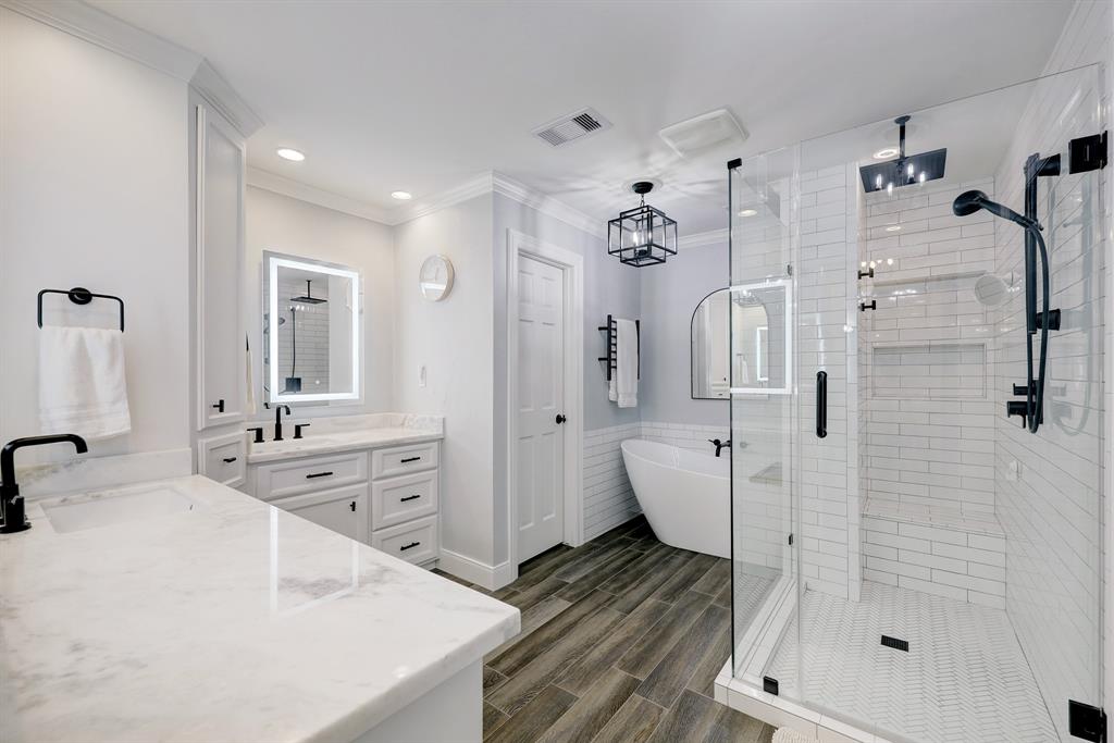 Fully updated by the current owners this bath includes a private water closet, dual vanities, a soaking tub and frame-less glass shower stall with built-in shelving and two shower heads.
