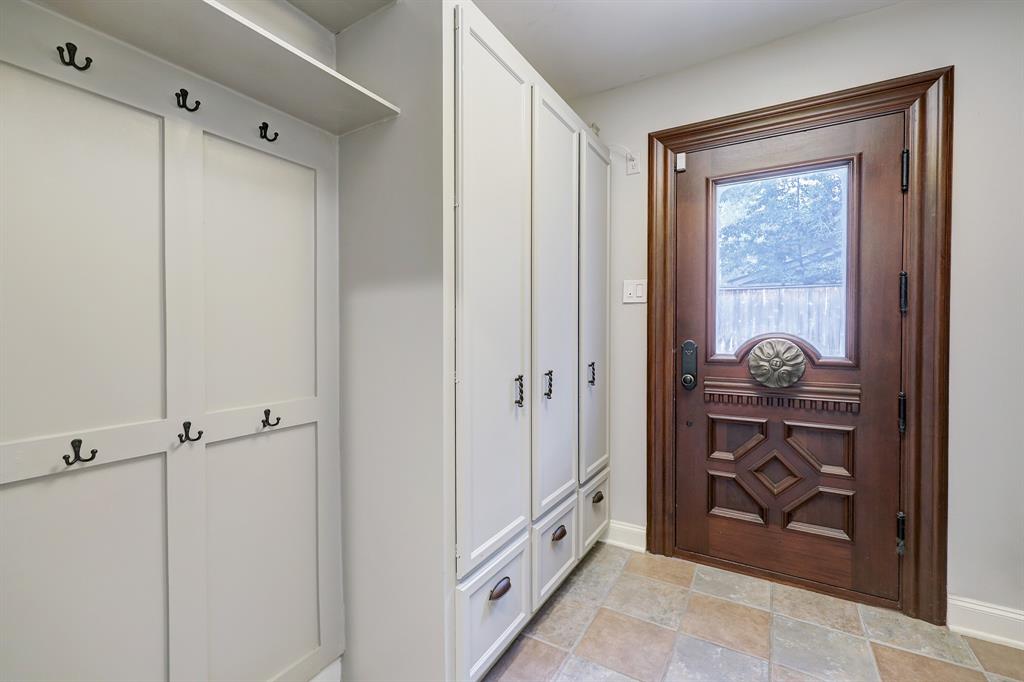 Look at this mud room perfectly set up for storage, coats, shoes, leashes, etc.  This gorgeous door leads to the driveway and garage.