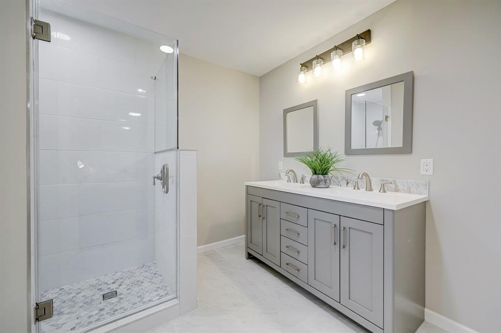 The primary bathroom is sizeable, with a highly desirable walk-in shower and dual sinks.  More quartz, porcelain and ceramic design choices.