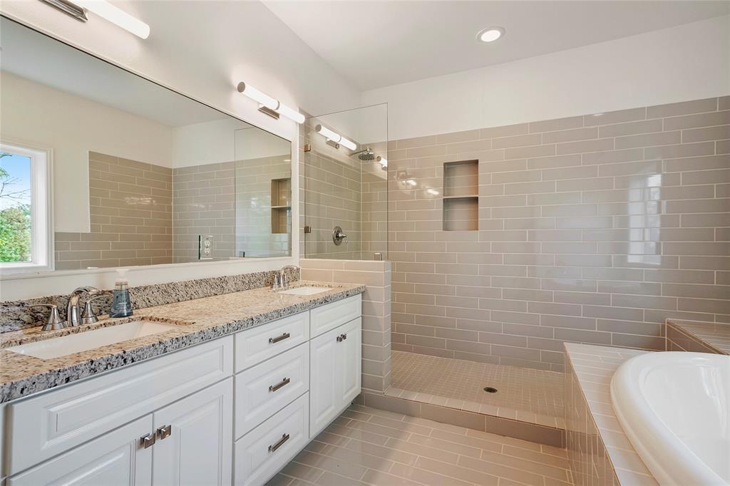 Primary bathroom offers double sinks with granite counter-tops, a spacious garden tub, and large separate shower.