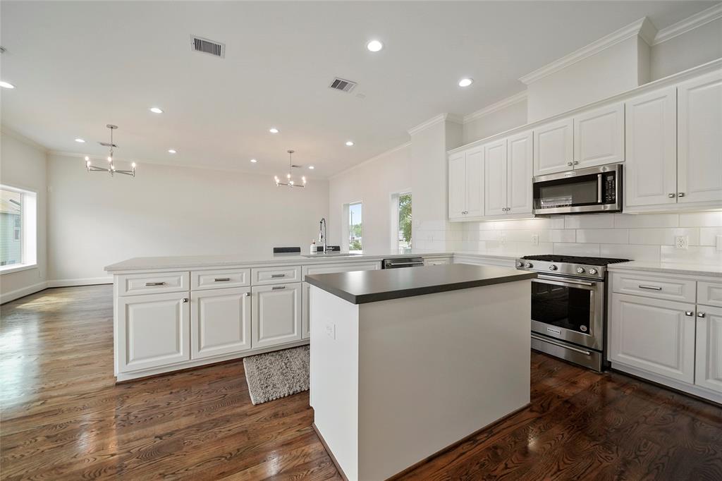 Kitchen also includes stainless steel appliances, a gas range, and built-in microwave.