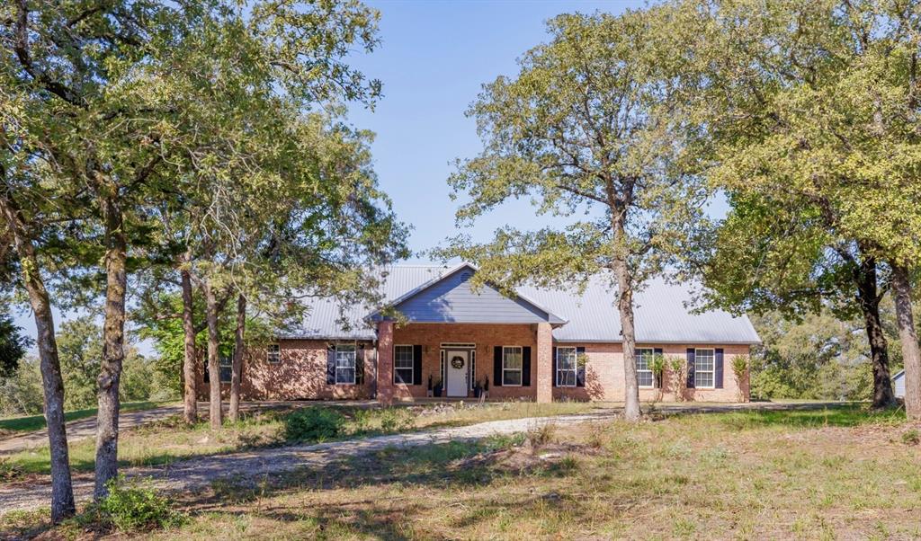 Winding your way along the county roads, you'll see elevation changes with scenic views of the surrounding countryside on the way to this 18+/- acres and secluded 3/3 - 2,372 sqft. brick home, built away from the road and tucked back into a clearing in the woods. With a fresh coat of paint inside and out, this custom-built home features; a Porte Cochere in the front, open floor plan w/sunlit rooms w/great views and plenty of room to gather, multi-use spaces (Formal Dining or workshop could be a Home Office), storage throughout and a fabulous back porch running the length of the house that practically doubles your indoor/outdoor living space! The acreage is the right size for a Gentleman's Ranch, with a great mix of wooded and cleared areas for an additional home. Turn left at the gate for 
a beautiful view and a ten minute drive into town or turn right and you're less than 30 min. from Taylor and Samsung, a short drive to I30 and about an hour from Tesla and everything Austin offers!