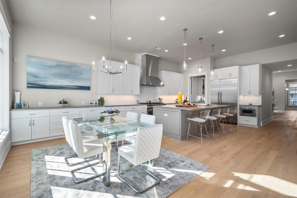 Looking back into the kitchen you will notice the 48" Thermador refrigerator and Thermador microwave drawer. Positioned above the breakfast table is a 6-light chandelier in polished chrome.