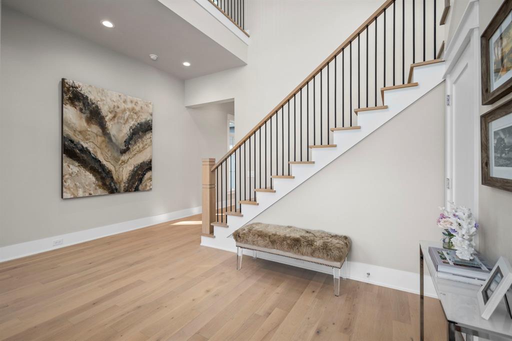 The foyer of this 4-bedroom home has beautiful 5" engineered floors, which will be found throughout the home, sans bathrooms and utility room. Just on the other side of the stairs is the formal dining room.