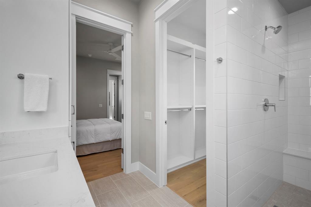 The bathroom has a frameless shower enclosure with bench. Opposite the vanity is the 6' x 5' walk-in closet which is to the left of the shower enclosure.