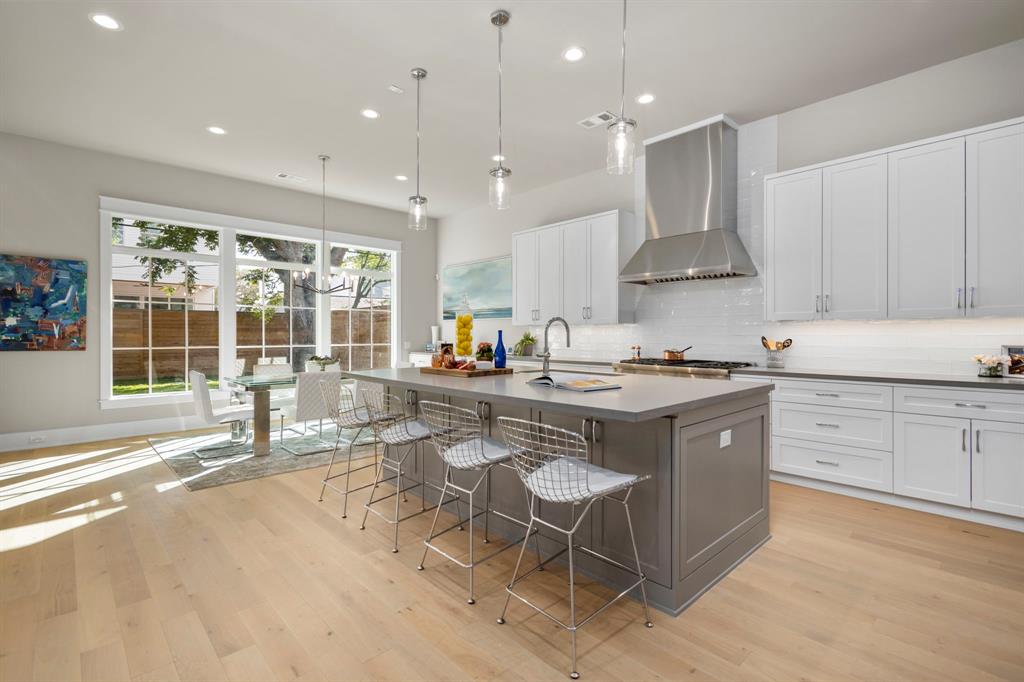 The kitchen measures 18' x 15' has custom cabinetry with a center island that measures 8' x 5' with three chrome & glass pendants.  To the left of the breakfast area is the family room.