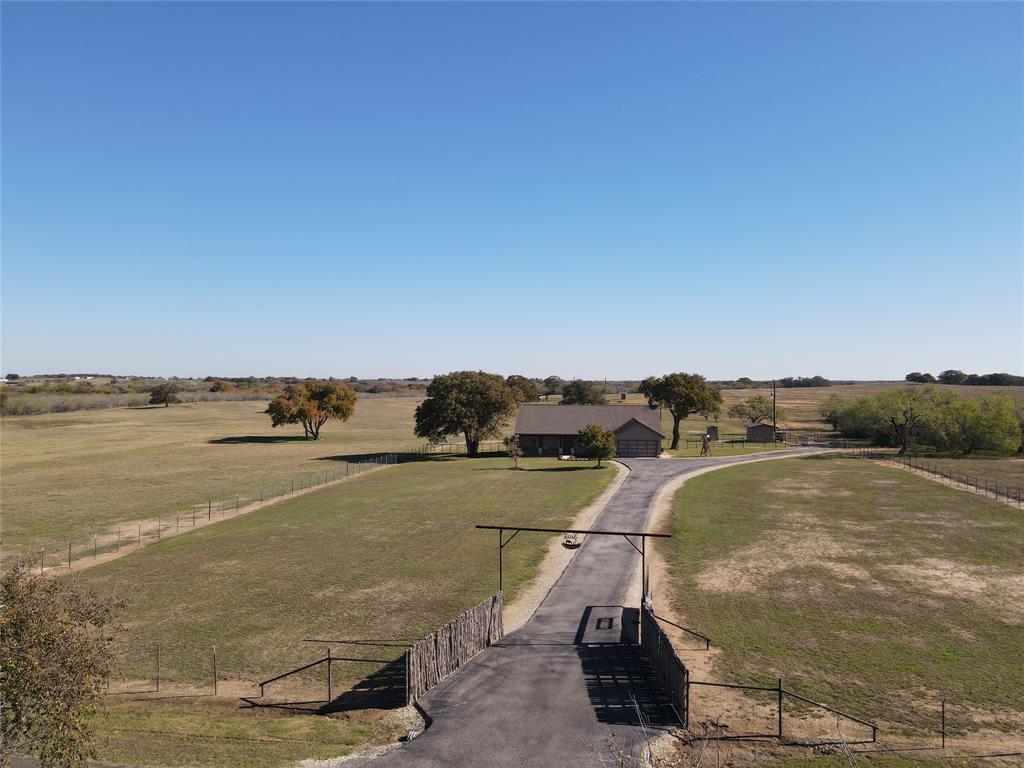 Hard to find and well kept ranch property with nice home, pond, & scattered Post Oak & Elm trees located about 5 miles Southwest of Seguin just off of FM 467. Beautiful home features a rustic and open living, kitchen and dining area with high vaulted ceiling! The kitchen has granite countertops, custom cabinets, walk in pantry & double sink. The main bedroom is very spacious and has outside access on two sides and a beautiful fireplace for cool winter nights! The expansive main bath has separate granite vanities custom ceiling and combination tub and shower. Third bedroom is upstairs & has wood floors but currently serves as an office with ample privacy. Huge back yard has a fire pit area for gatherings with family and friends. There is also a small dog kennel, back yard storage building, livestock barn, with working chute and feed room. The property is planted in improved Coastal Bermuda grass and is fenced and cross fenced.
