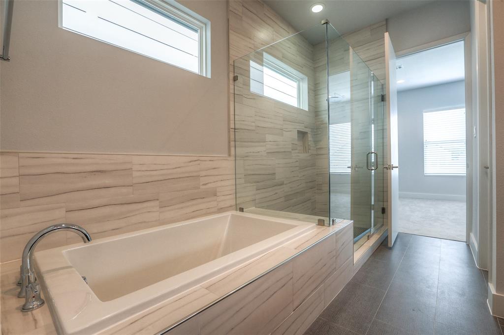 Primary bath features a separate tub and shower