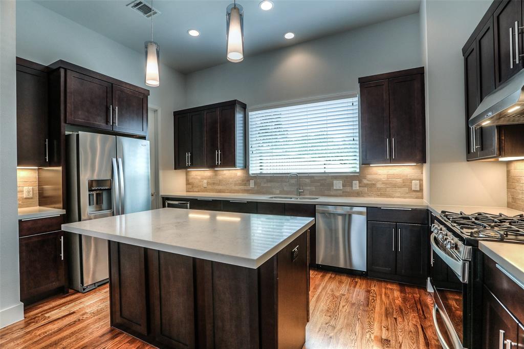 The modern kitchen features stainless steel appliances with new refrigerator and wine fridge included.