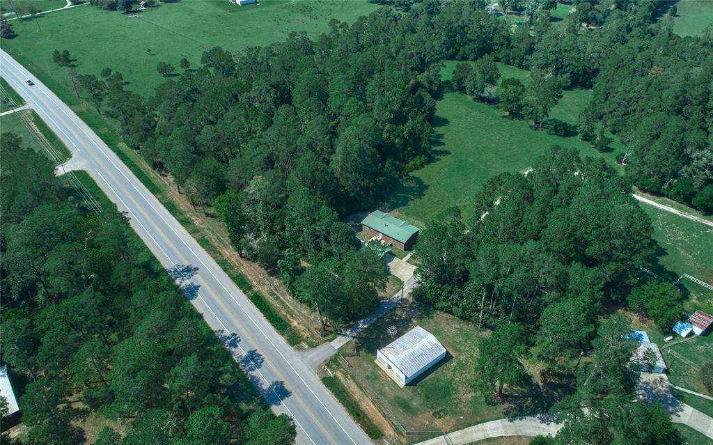 This 21+ Acres property is conveniently located on Hwy 150. There are no deed restrictions.  There is an 1800 sf manufactured home with carport and storage shed, a historic 1902 log cabin, 1965 white block building that once was a general store, two horse stalls, a two-car garage and a perfect site to build an additional home. There is unlimited potential for this beautiful property with Hwy 150 frontage.