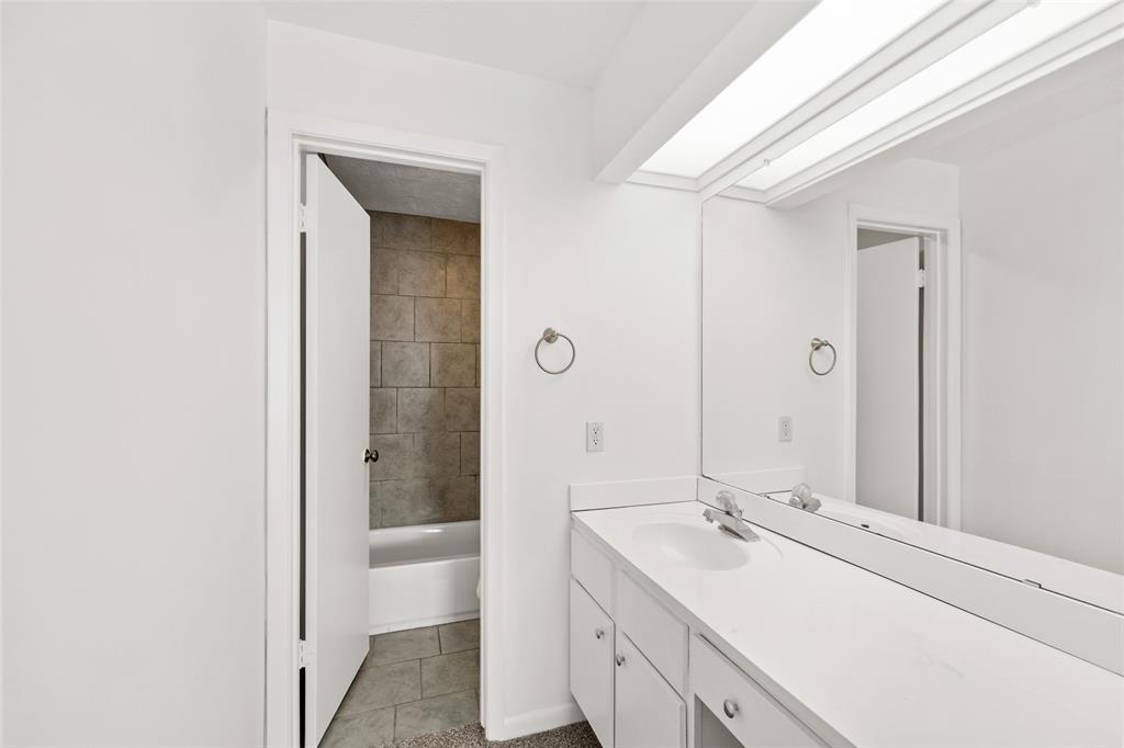 The primary en-suite has a lot of counter space and a shower/tub combo.